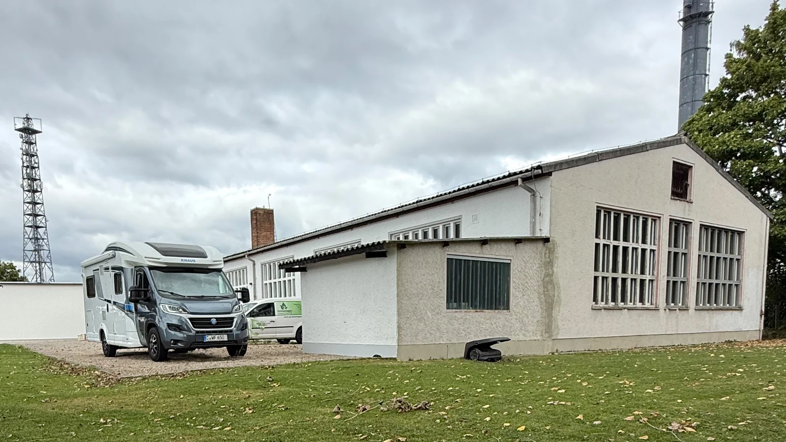 Wohnmobil neben einer weißen Halle auf dem Gelände des Gewerbeparks